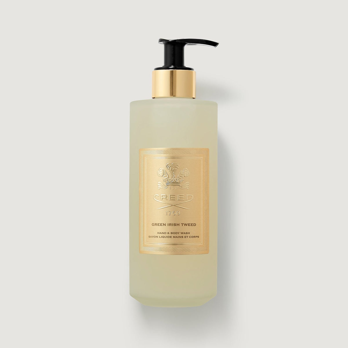 Bottle of Green Irish Tweed body lotion with a gold label on a light gray background