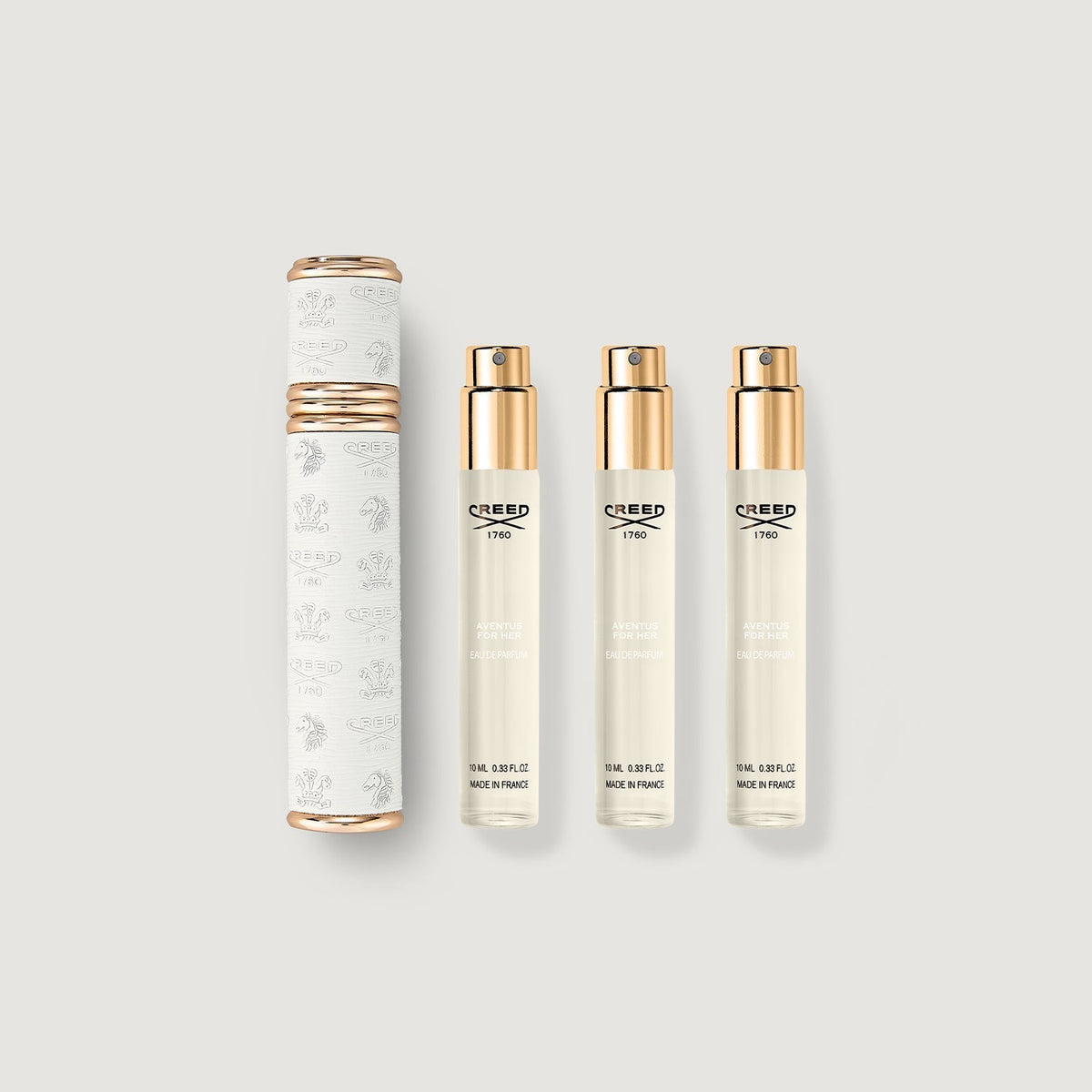 Set of Creed perfume bottles and packaging on a light gray background